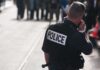 Attempted Beheading Shocks Belfast Police officer in uniform communicating with a crowd in an urban setting