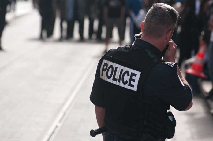 shutterstock_63401140 Police officer in uniform communicating with a crowd in an urban setting