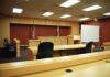 Top Diplomat Confesses to Cuba Espionage Interior view of an empty courtroom with wooden furniture and American flags