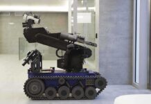 A robotic arm mounted on a tracked base in a modern workspace