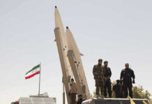 Trump’s “Kill List” Claim Sparks New Questions Military personnel beside missiles and Iranian flag.