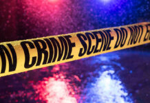 Holiday Chaos: Kids Hit During Fireworks Yellow crime scene tape with police lights in background.