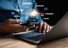 Person using smartphone and laptop with AI hologram