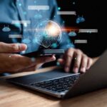 Person using smartphone and laptop with AI hologram