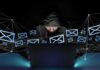 Cyberattack Disrupts Suisun City’s 911 System Hooded person using a laptop surrounded by email icons