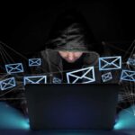 Cyberattack Disrupts Suisun City’s 911 System Hooded person using a laptop surrounded by email icons