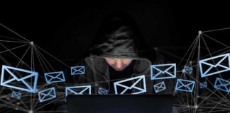 Hooded person using a laptop surrounded by email icons