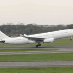 White commercial airplane taking off from runway