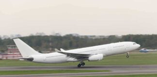 White commercial airplane taking off from runway