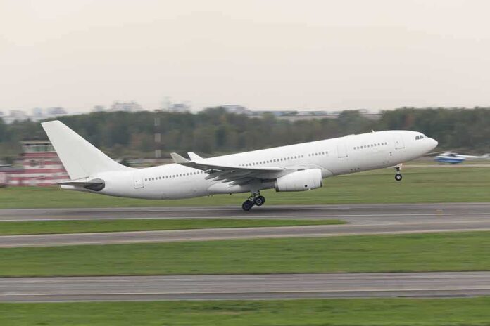 White commercial airplane taking off from runway
