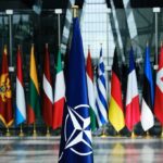 New Strike Raises Wider War Risks NATO flag with member country flags in the background