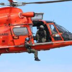 Rescue helicopter with crew performing hoist operation