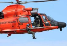 Rescue helicopter with crew performing hoist operation