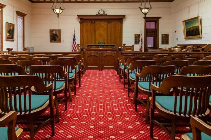 shutterstock_1631139556 Courtroom with wooden benches facing the judge's bench