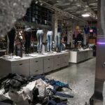 clothing store interior with broken glass and scattered garments