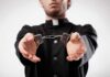 Person in black robe holding handcuffs forward