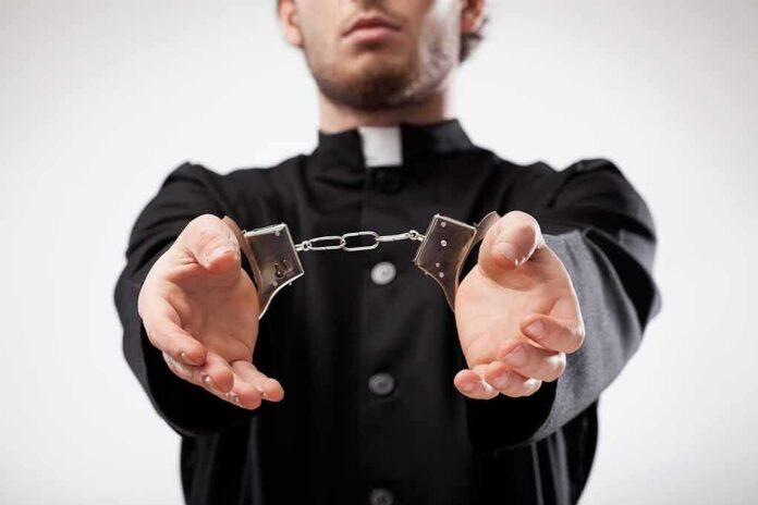 Person in black robe holding handcuffs forward