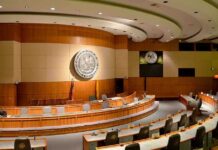 Interior view of a government chamber with wooden paneling and seating