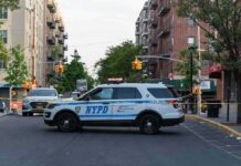 NYPD police SUV blocking a city street at a taped-off scene