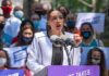 NYC Mayor Mourns Rikers Detainee Woman speaking at outdoor rally behind microphones