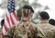 soldier in camouflage with braided hair and beret