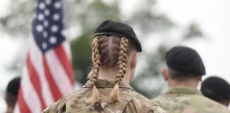 soldier in camouflage with braided hair and beret