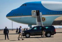 U.S.-Russia Talks Move Behind the Scenes Security detail near blue and white aircraft with staircase and SUV