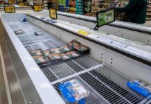 supermarket freezer with mostly empty shelves and a few meat packages