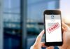 Impostor Message Triggers Security Alert Hands holding smartphone showing scam text marked fake
