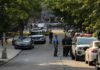 Police Seize Guns, Ammo in Minneapolis Apartment Raid Police officers secure a residential street with patrol cars and yellow tape