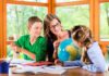Homeschooling Remains Far Above Old Levels Teacher with two children studying a globe at a table