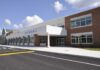 Villages Fear Migrant Housing Plan Near Schools Modern school building with large windows and a clear sky