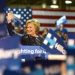 woman waving at a rally podium