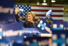 Senate Race Ignites Debate Over El-Sayed’s Allies woman waving at a rally podium