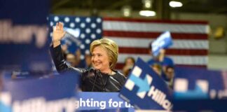 woman waving at a rally podium