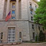DOJ Probes Claims of Anti-Trump Plot Stone government building with American flag at entrance