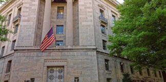 Stone government building with American flag at entrance