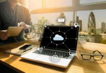 Laptop on desk showing cloud network icons