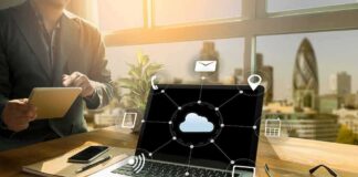 Laptop on desk showing cloud network icons