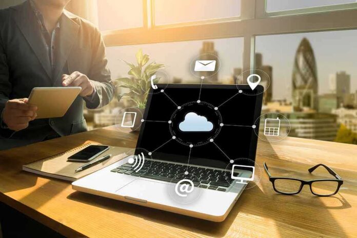 Laptop on desk showing cloud network icons