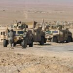 U.S. Troops to Leave Iraq After 23 Years Soldiers near armored vehicles in a desert