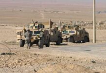 U.S. Troops to Leave Iraq After 23 Years Soldiers near armored vehicles in a desert