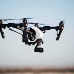 Quadcopter drone with camera flying outdoors