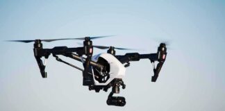 Quadcopter drone with camera flying outdoors