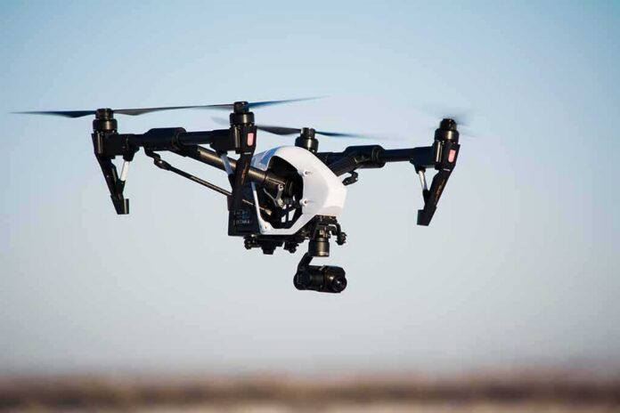 shutterstock_777450178 Quadcopter drone with camera flying outdoors