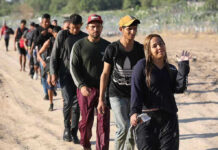 Migrant Caravan Marches From Southern Mexico Line of people walking along a dirt path outdoors