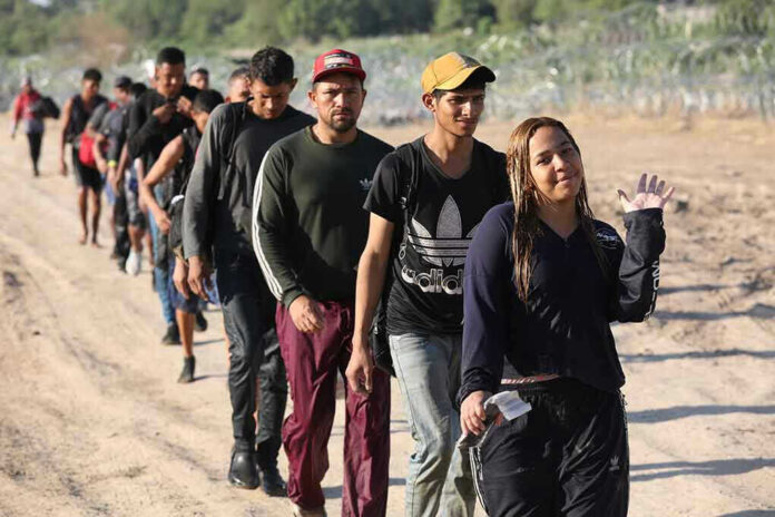 2364873693 Line of people walking along a dirt path outdoors