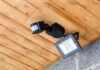 Outdoor LED floodlight with motion sensor on wooden ceiling
