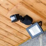 Outdoor LED floodlight with motion sensor on wooden ceiling