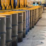 Rows of industrial metal barrels with yellow lids